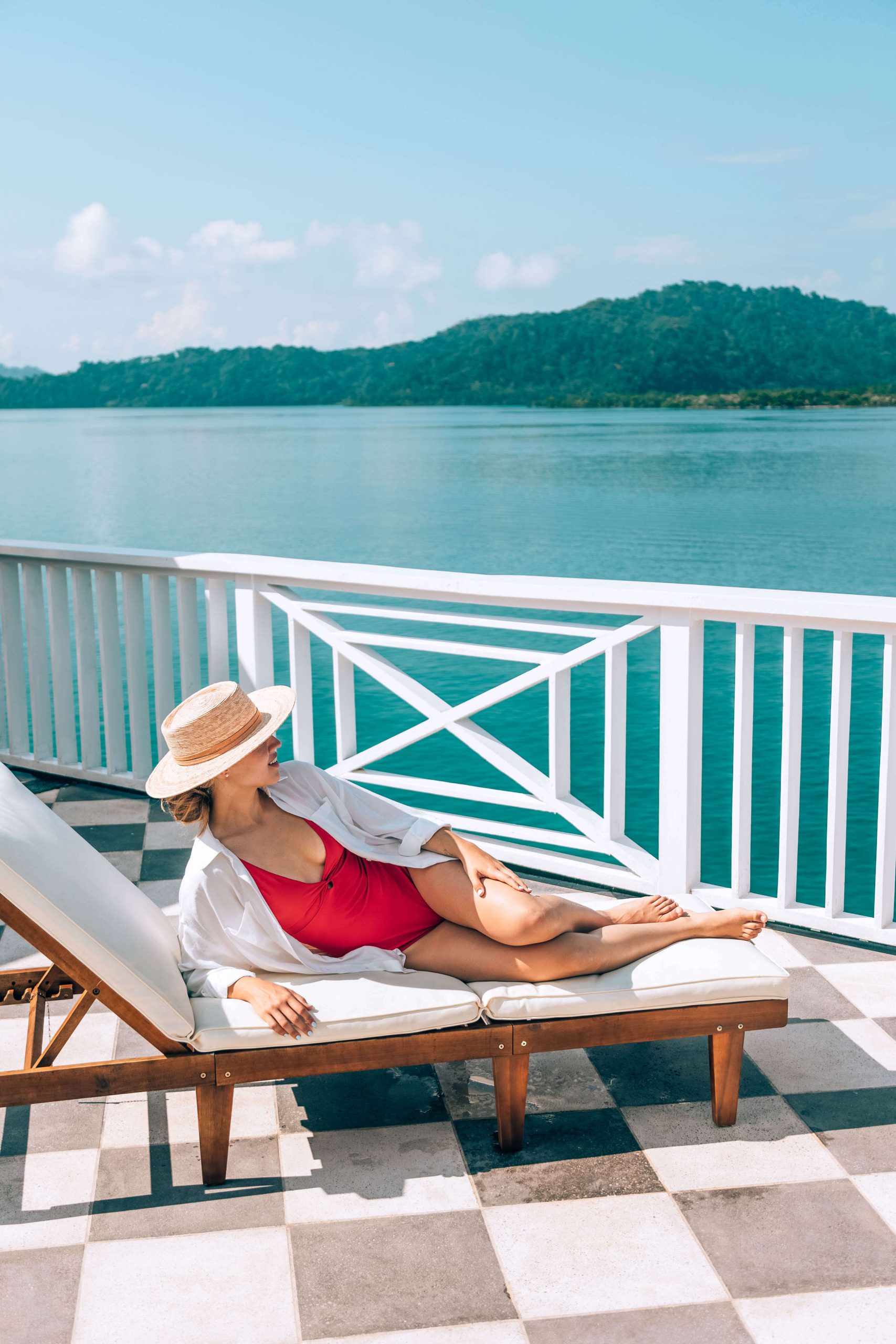 Woman relaxing on a marina terrace overlooking turquoise Golfo Dulce waters