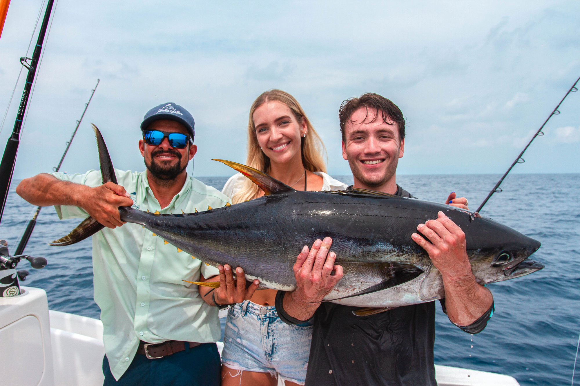 Group holding a yellowfin tuna catch after sportfishing in Golfo Dulce