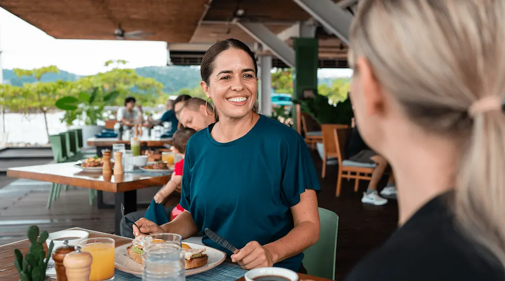 Friends enjoying breakfast at a waterfront restaurant overlooking the Golfo Dulce at Marina Bahia Golfito