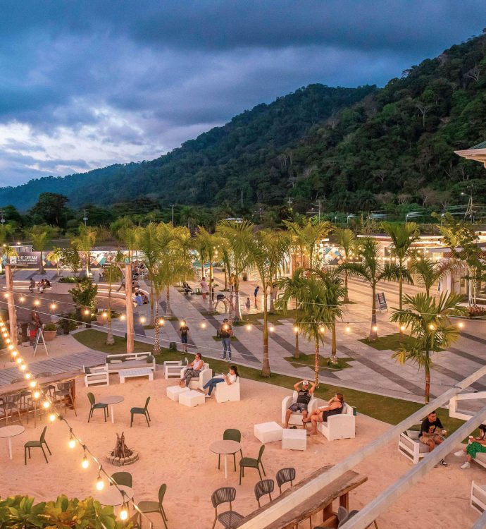 Enjoy Group coastal plaza at dusk with string lights and palm trees, Southern Zone Costa Rica